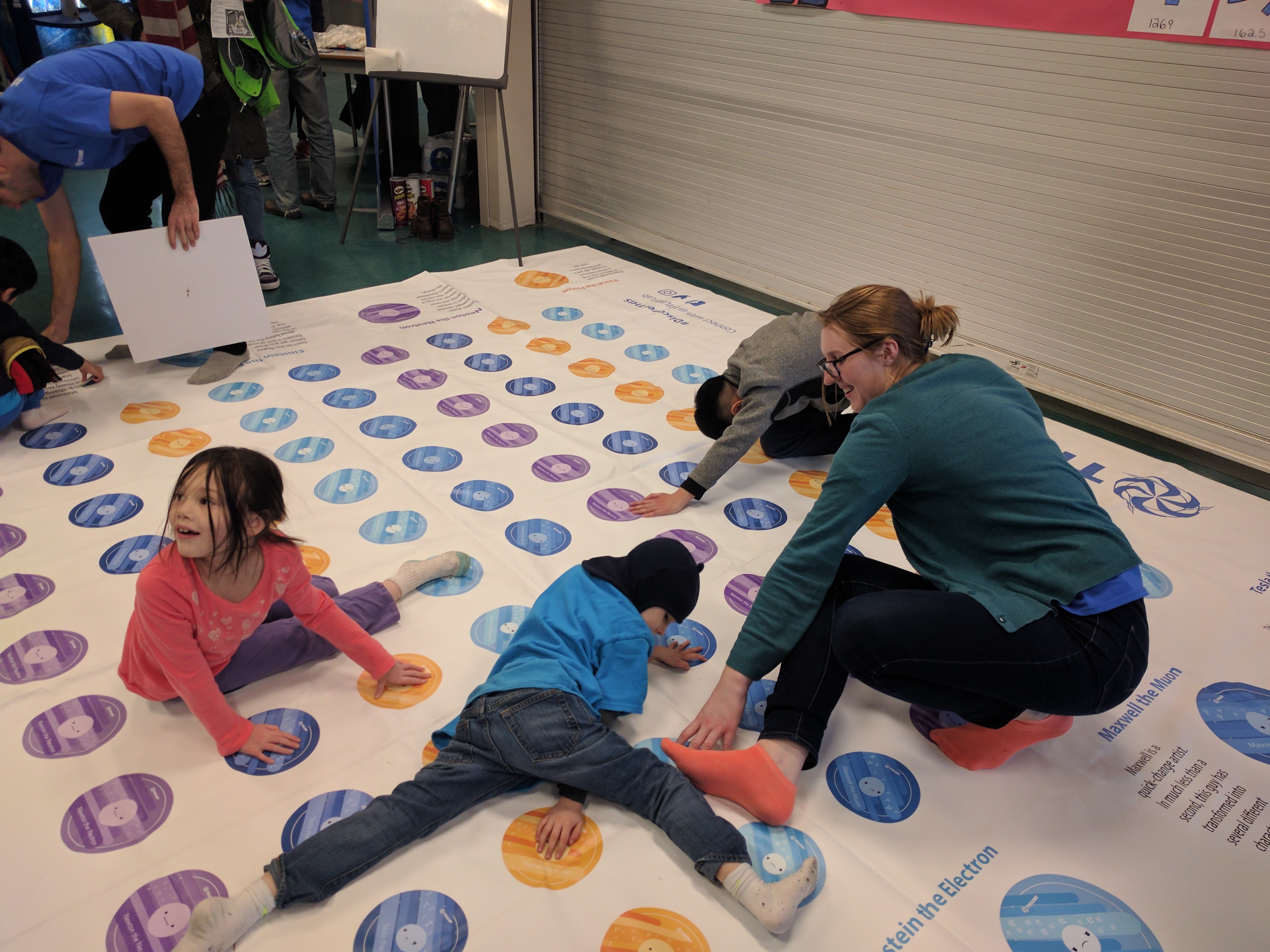 Samantha plays particle Twister at a TRIUMF event.