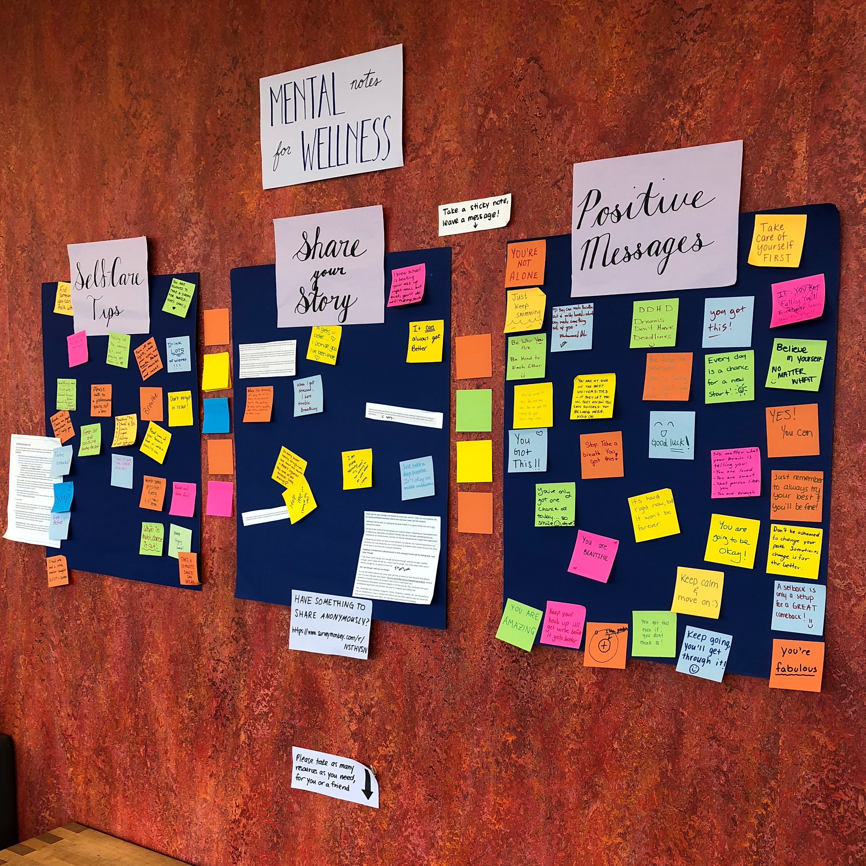 Poster boards invite sticky note conversations about mental well-being during a Peer Health Education campaign.